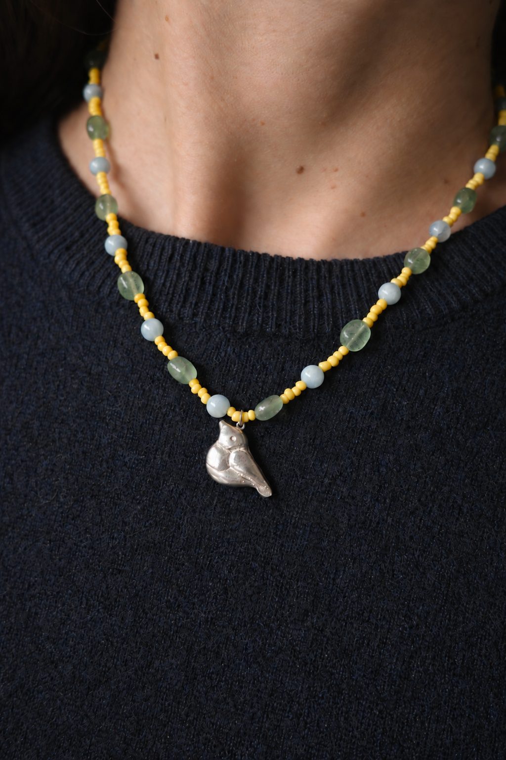 Vitamin D necklace with bird pendant, worn